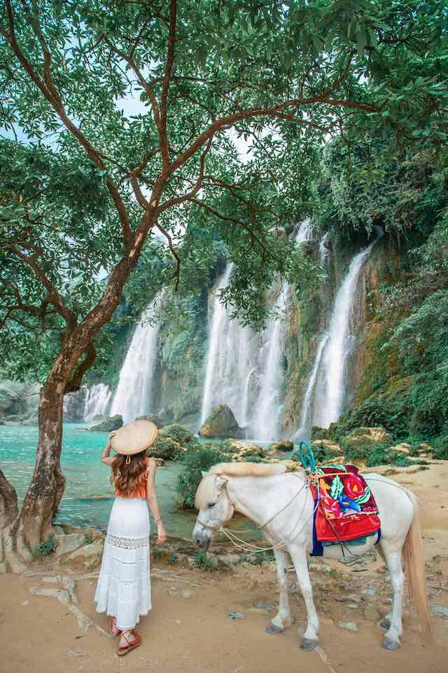 A Vietnamese take a photo with horse in Ban gioc falls